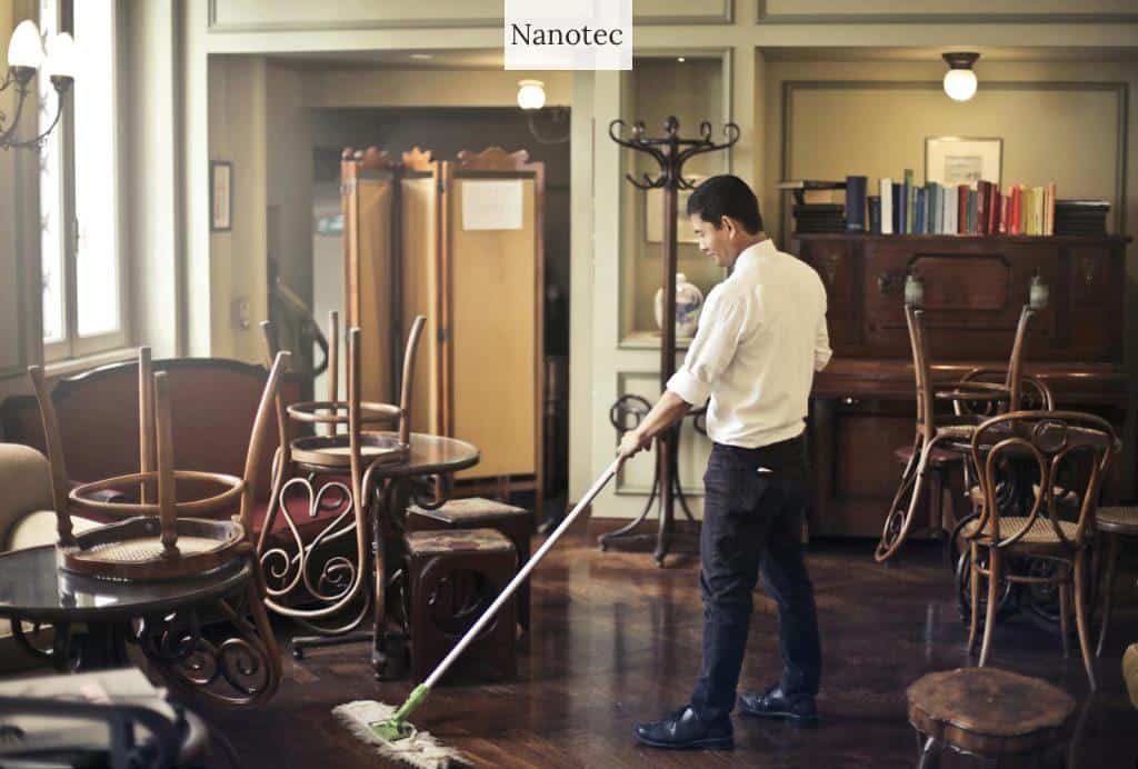 Male employee cleaning floor in restaurant
