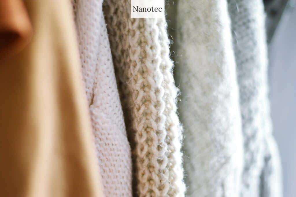 Detailed view of multiple woolen knitted sweaters in soft, neutral colors emphasizing texture and warmth.