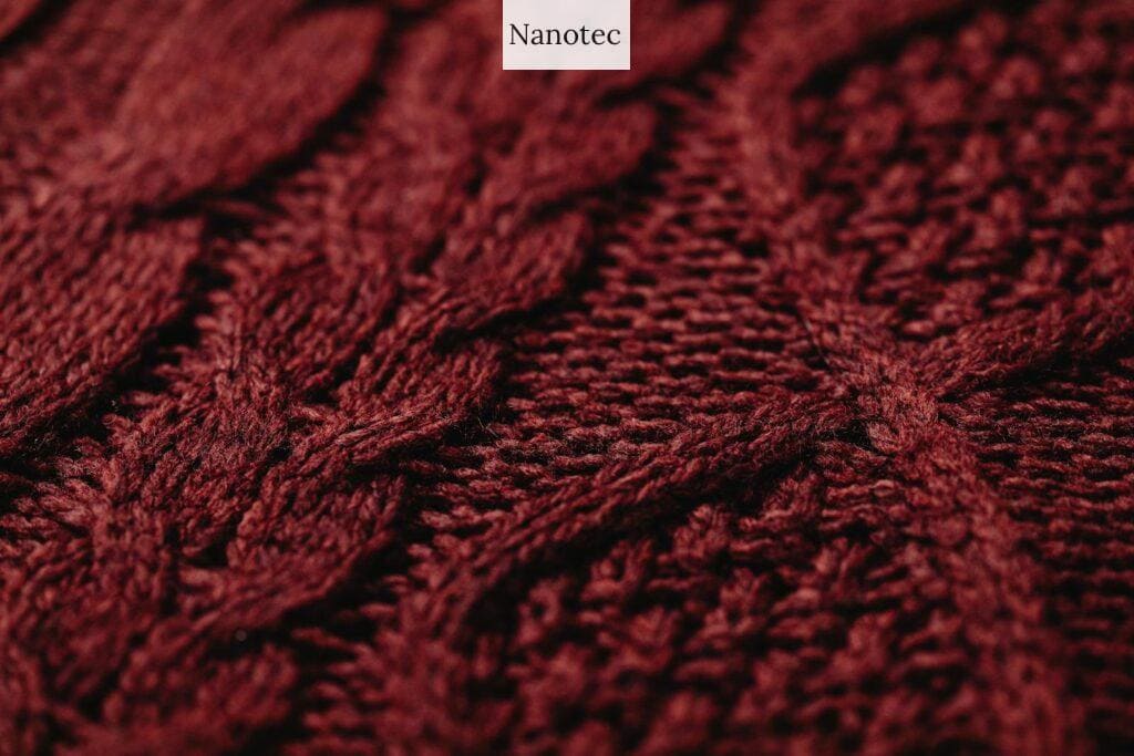 Detailed view of a burgundy knitted textile fabric showcasing intricate patterns and texture.