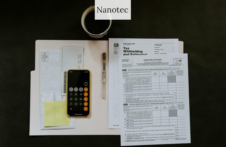 black Android smartphone near ballpoint pen, tax withholding certificate on top of white folder